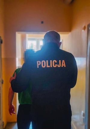 zdjęcie przedstawia policjanta z zatrzymanym