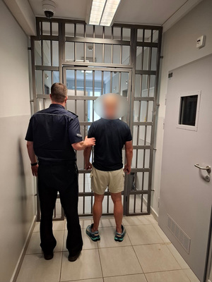 Zdjęcie przedstawia policjanta z zatrzymanym